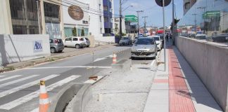 obra na esquina aumentada com carros estacionados na rua ao fundo