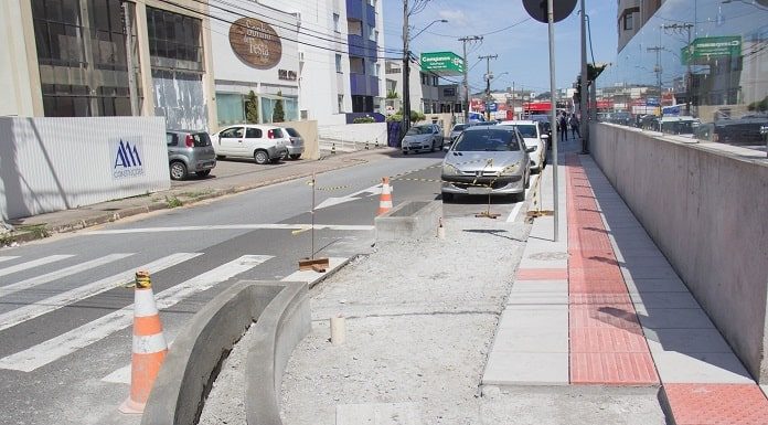 obra na esquina aumentada com carros estacionados na rua ao fundo