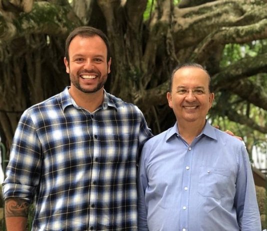 pedrão e jorginho mello sorriem lado a lado para a foto com a figueira da praça xv ao fundo