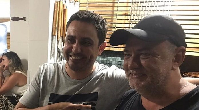 fernando anselmo e amauri dos projetos abraçados e sorridentes segurando ficha de filiação