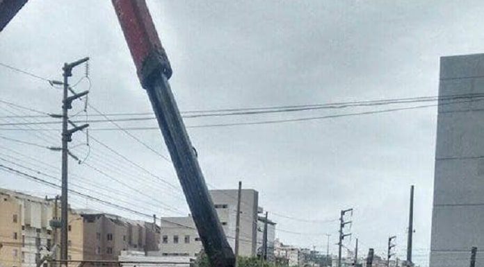 garra mecânica de caminhão pega diversas bicicletas colocadas lado a lado em área ao ar livre