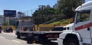 guincho parado no meio das pista da beira-mar com outro guincho maior atrás