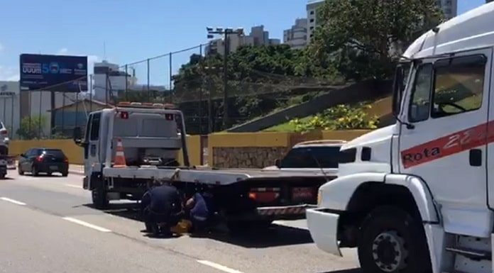 guincho parado no meio das pista da beira-mar com outro guincho maior atrás