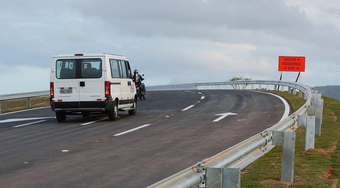 van passando em curva de viaduto em trecho do novo acesso com placa "conversão à direita"