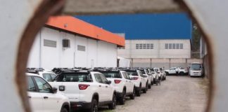 fiat toro estacionadas juntas em pátio vistas por um buraco no portão