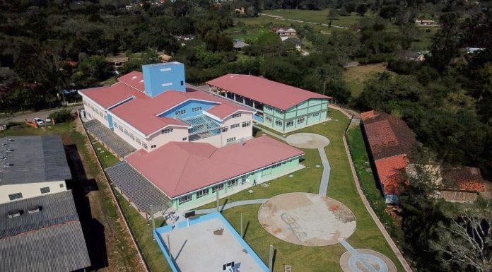 foto aérea de prédio e pátio da escola no ratones, com campos e vegetação em volta