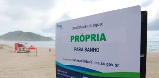 placa do ima em praia com destaque para a frase "própria para banho"