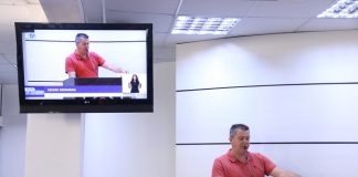 roinoldo na tribuna da câmara com televisor ao lado transmitindo seu discurso