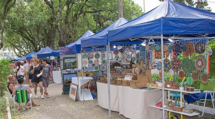 barracas de feira na praça e pessoas andando