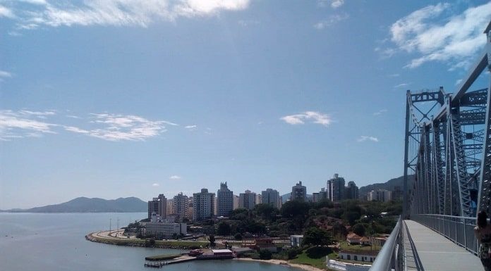 foto da baía norte de florianópolis a partir da ponte hercílio luz mostrando um dia de sol e a beira-mar