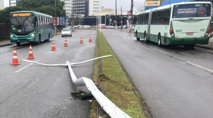 poste caído no canteiro central da avenida com cones delimitando e ônibus da jotur ao fundo e outro do outro lado