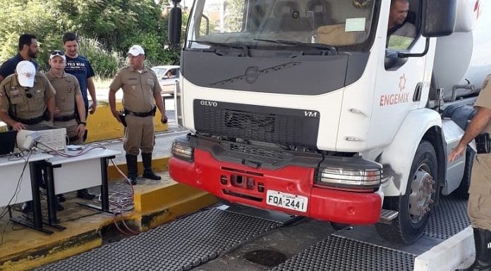 caminhão estacionando sobre a balança com policias em volta