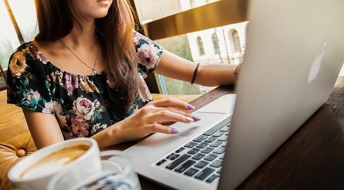 mulher trabalhando no notebook com xícara de café ao lado