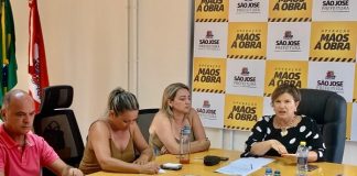 prefeita e secretárias reunidas em volta de uma mesa e painel com logos de são josé ao fundo