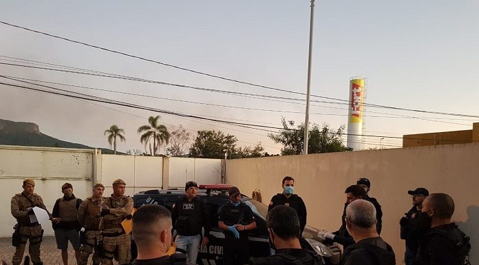 Policiais armados cumprindo mandados de busca