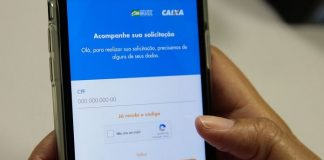 pessoa segura celular com aplicativo da caixa aberto na tela