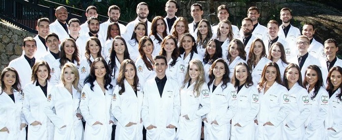 foto de formatura com as 46 pessoas posando para foto usando jaleco