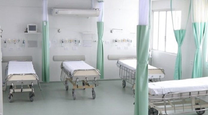 quatro camas de hospitais separadas por cortinas recolhidas