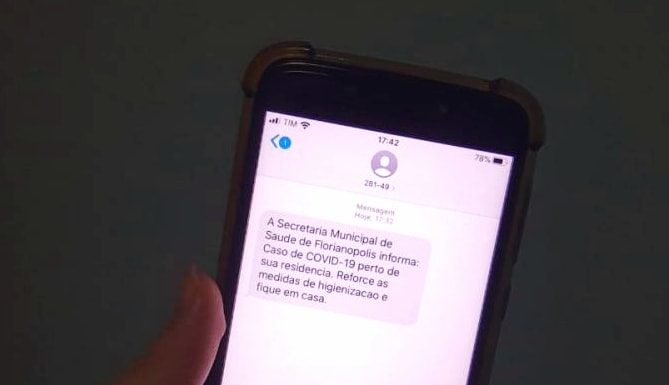 close em tela de celular com mensagem de alerta de proximidade de caso de coronavírus