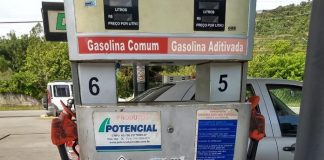 Fiscais do Procon colando adesivo na bomba de gasolina