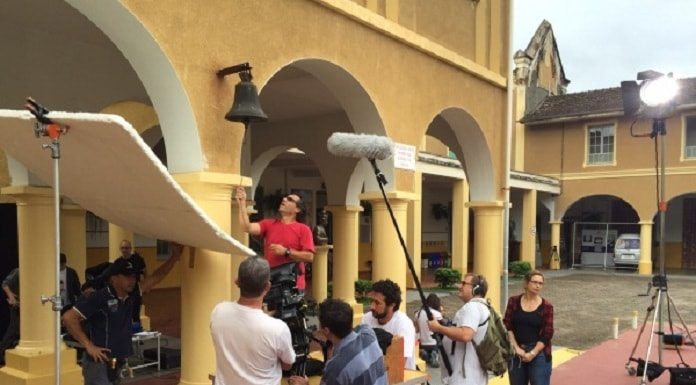 profissionais em set de filmagem da série, mexendo em equipamentos de filmagem