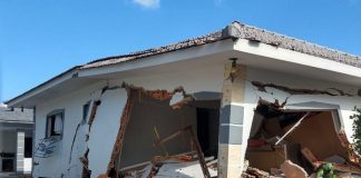 casa com grandes rachaduras e praticamente destruída, com detritos espalhados