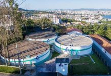 reservatórios circulares da casan no topo do morro do centro histórico de são josé com a cidade ao fundo