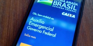 Auxílio Emergencial: Celular em cima da mesa com o aplicativo CAIXA Tem aberto.