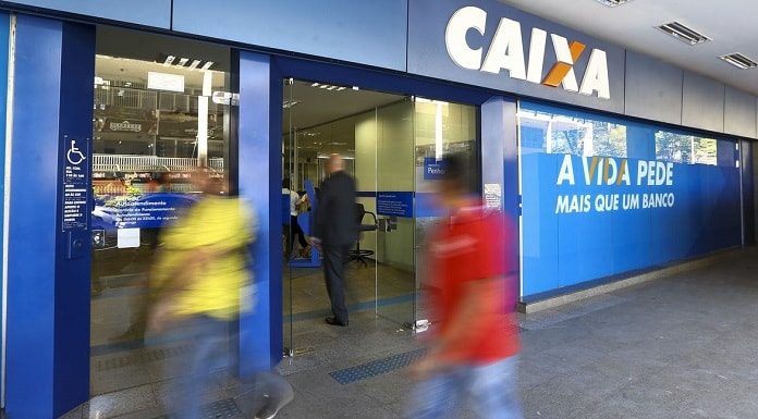 borrão de pessoas andando em frente à agência da caixa