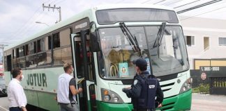 dois ficais e um guarda do município de palhoça em frente a um ônibus da jotur