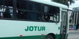 ônibus da empresa jotur visto de lado com logo em evidência no centro da foto