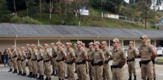 tropa de cerca de 30 policiais militares em posição de sentido