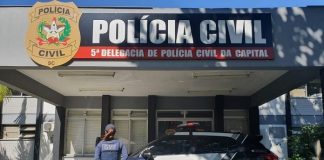 policial feminina de costas perto de uma viatura