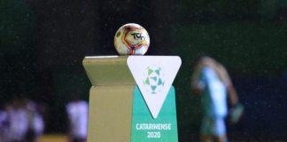 bola de futebol sobre uma bancada personalizada com logos do futebol catarinense 2020