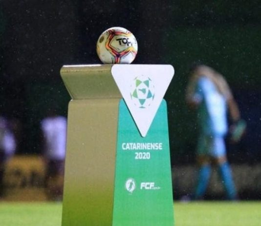 bola de futebol sobre uma bancada personalizada com logos do futebol catarinense 2020