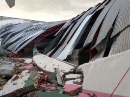 ginásio de escola destruído com escombros de alvenaria e o galpão desabado