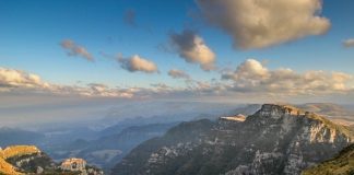 morro da pedra furada com montanhas em volta e vale ao fundo, nuvens no ceu