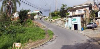 trecho em duas cuvas mais íngremes da rua com moto no alto e casas em volta