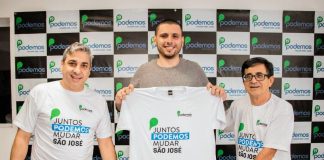 Marcondes, Costa e Natal posam para foto uniformizados com camisa do partido e sorridentes. Painel de logos do partido ao fundo