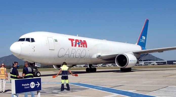 operário sinaliza para taxiamento da aeronave com inscrição latam cargo