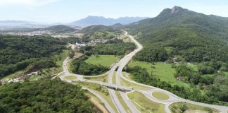 foto aérea do contorno viário onde há rotatórias e morro da pedra branca ao fundo