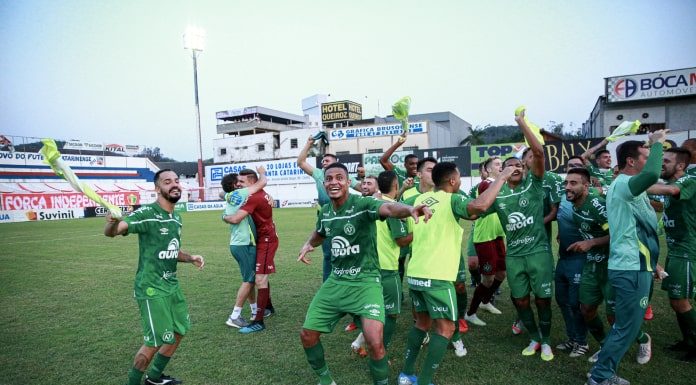 jogadores da chapecoense uniformizados fazendo festa e comemorando em campo