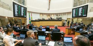 homens sentados naplenário da câmara dos deputados com computadores a frente