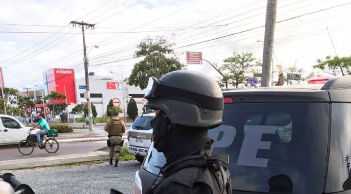 policial do bope com metralhadora ao lado de caminhonete nos ingleses