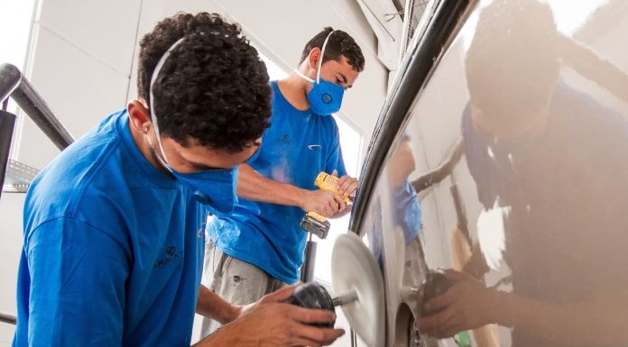 dois homens usando máscaras fazendo polimento de casco brilhante