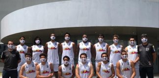 equipe masculina do basket são josé posa para a foto de uniforme. Seis estão com o joelho apoiado no chão e oito em pé, ao lado de dois membros da comissão técnica vestidos de preto.