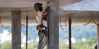 Homem com equipamentos de EPI, realizando obra