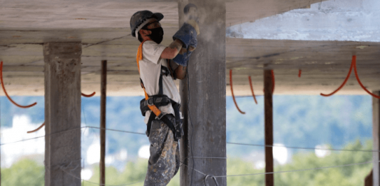 Homem com equipamentos de EPI, realizando obra