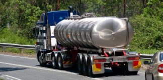 Restrições tráfego caminhões - Caminhão; veículo longo andando na rodovia com um carro atrás na pista