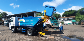 Caminhão da Comcap na rua com funcionários